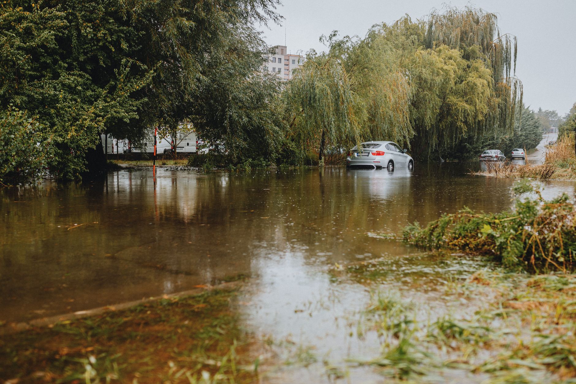 pexels-photo-28447757 car navigating flooded road in urban area